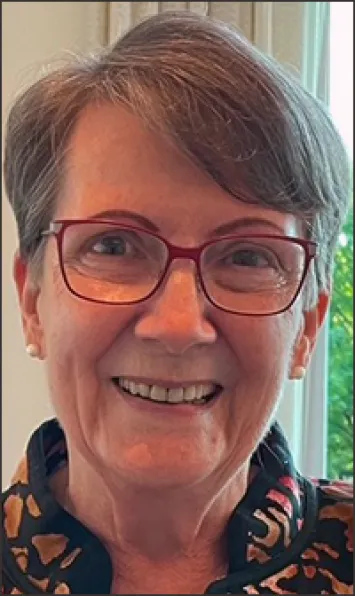 Smiling older woman with short gray hair and glasses