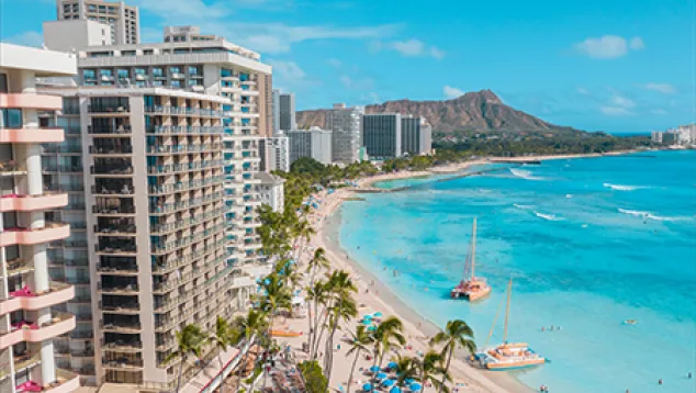 Beachfront hotels and shoreline with mountain backdrop