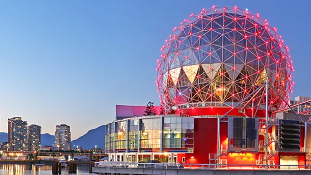 Modern building with geodesic dome and city skyline reflection