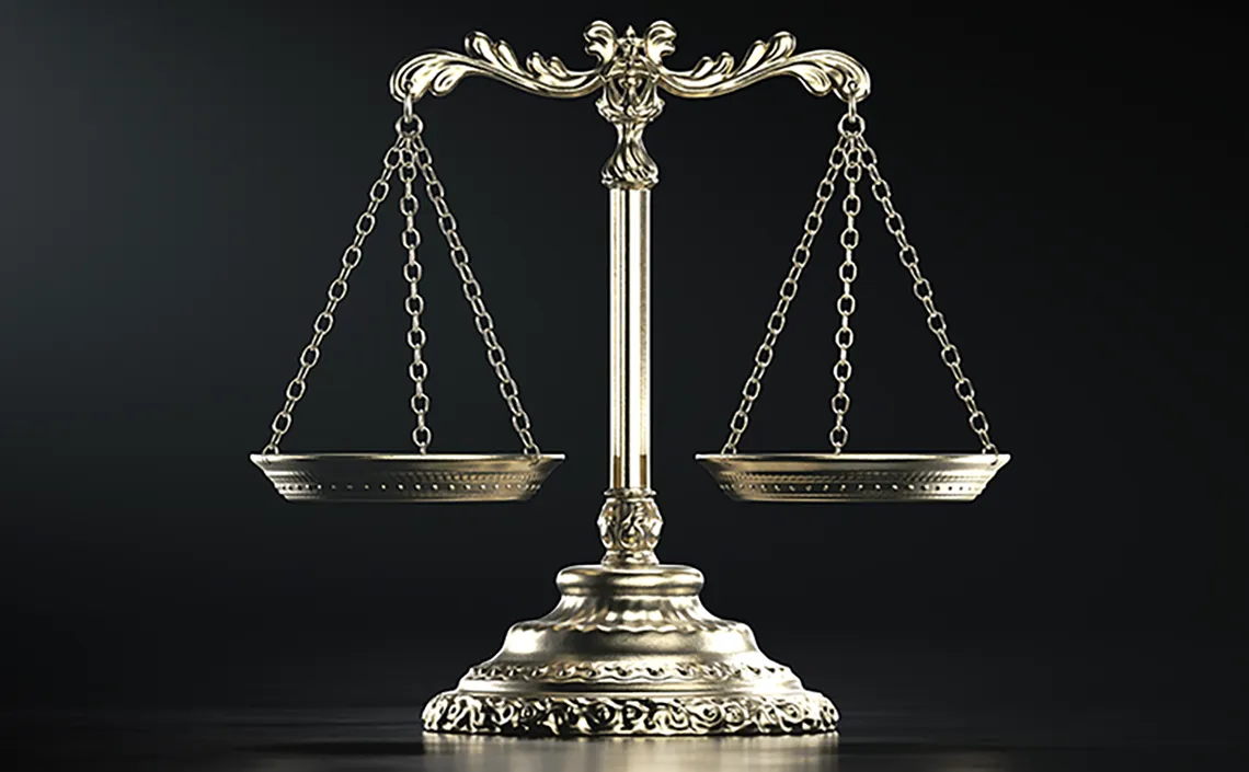 Gold balance scale of justice on black background