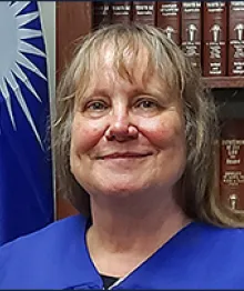 Female judge in judicial robes with books background